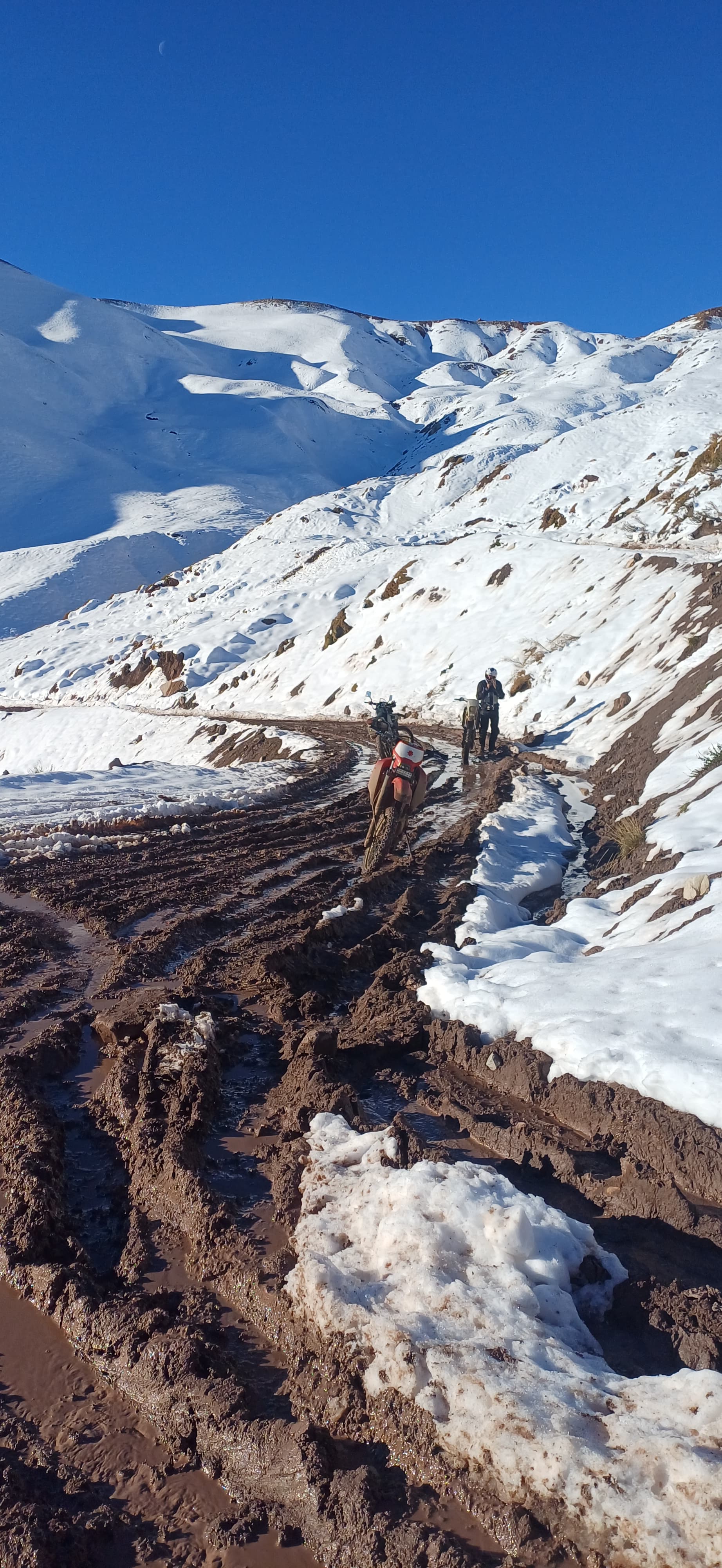 Camino de ripio atravesando un paisaje de alta montaña del oeste argentino.